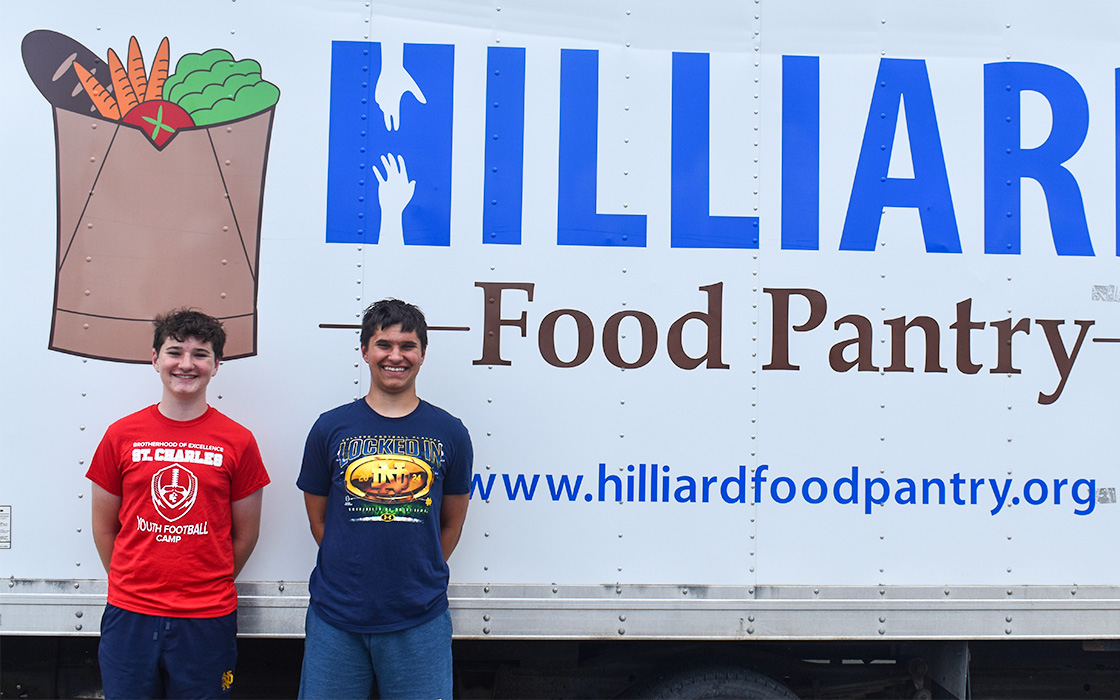 Photo of two young men in front of the Hilliard Food Pantry truck