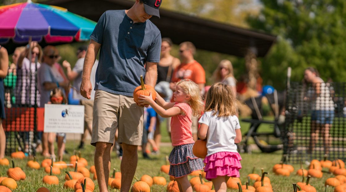 girls choosing pumpkins