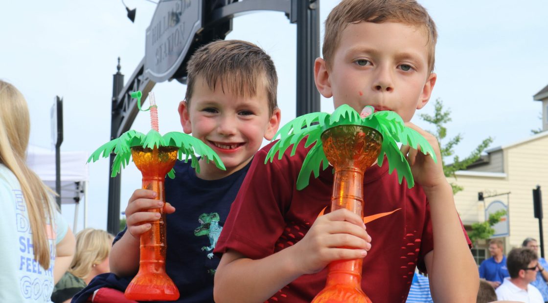 Boys drinking from palm tree cups